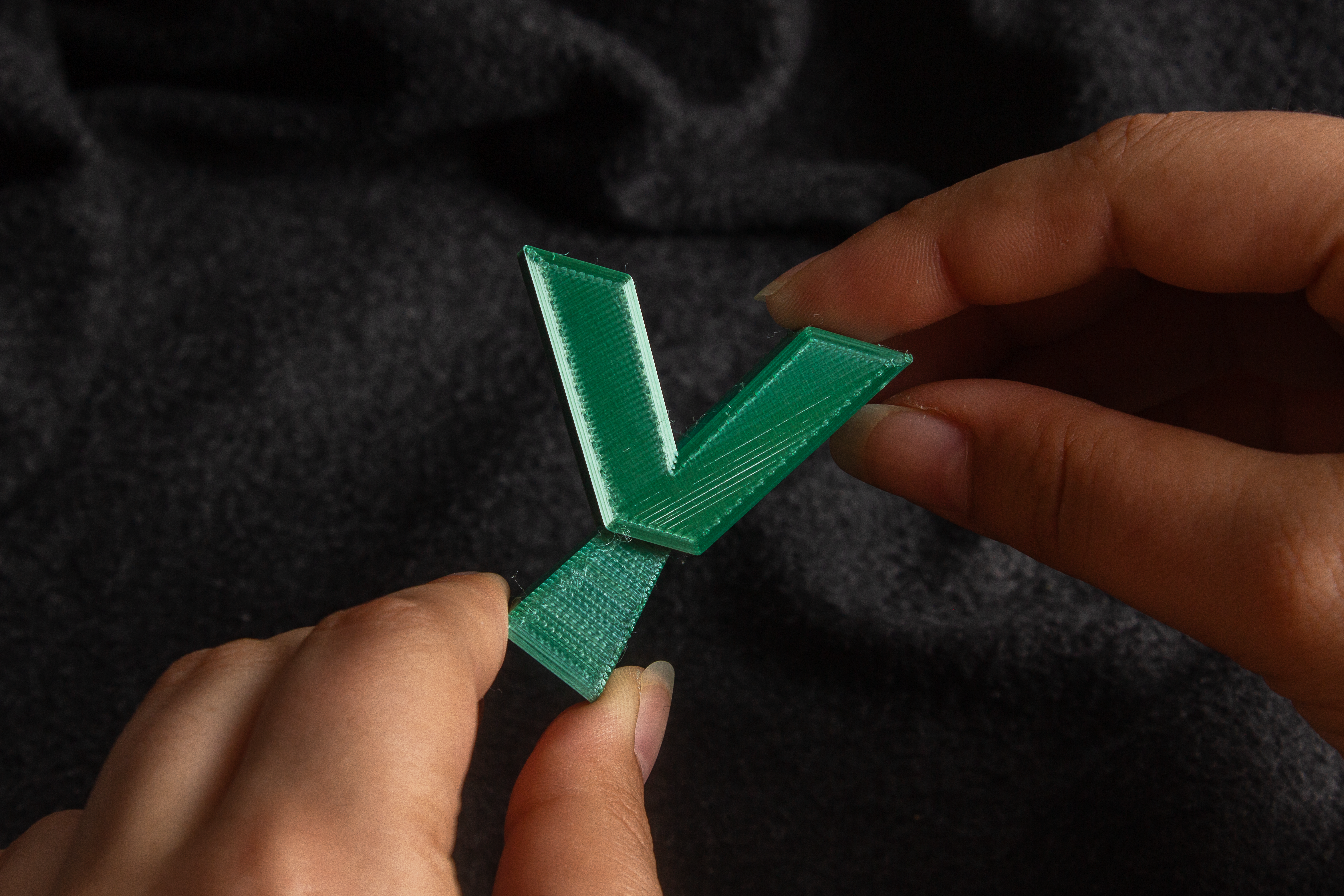 Hands playing with a letter Y-shaped 3D printed fidget toy. It works similar to a light switch